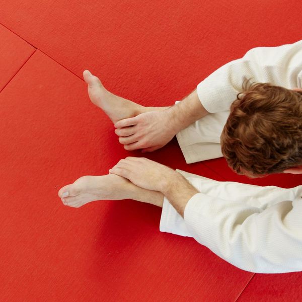 A man holding a challenging balance pose, showcasing focus and stability.